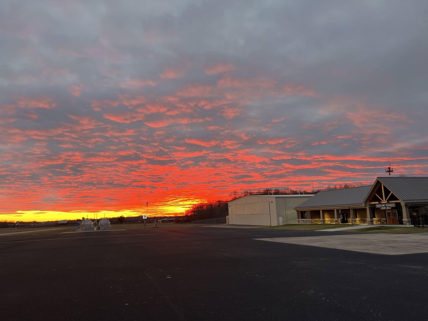 The ramp and hangars at Taylor County Airport at sunset, seen from the terminal apron.