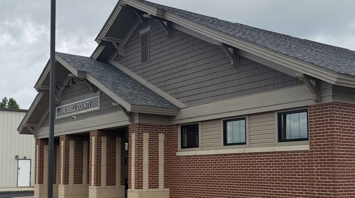 The terminal building at Russell County Airport, brick and timber under a grey sky.